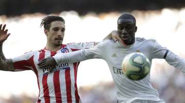 Atletico Madrid's Sime Vrsaljko, left, challenges for the ball with Real Madrid's Ferland Mendy during a Spanish La Liga soccer match between Real Madrid and Atletico Madrid at the Santiago Bernabeu stadium in Madrid