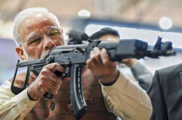 Prime Minister Narendra Modi tries a weapon during the inauguration of 11th edition of DefExpo 2020,