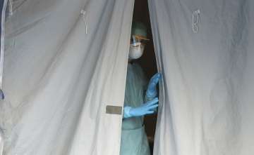 A medical staffer watches from a tent at one of the emergency structures that were set up to ease pr