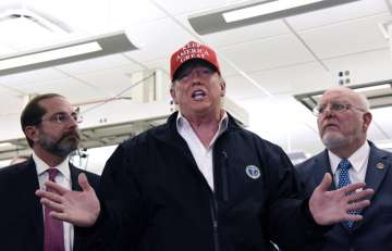 President Donald Trump speaks to members of the press as Health and Human Services Secretary Alex Az