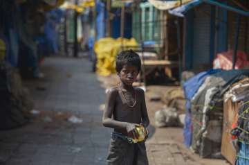 A homeless boy collects rotten fruits from a deserted fruit market during lockdown in Gauhati, India