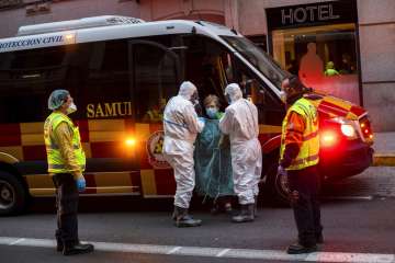 A patient, center, is transferred to a medicalised hotel during the COVID-19 outbreak in Madrid, Spa