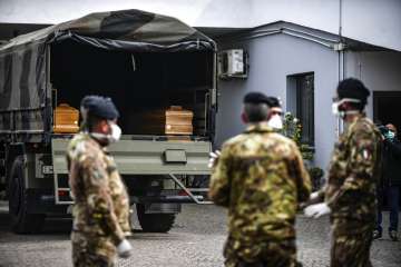 Italian army soldiers wait for coffins they took from the Bergamo area, where the coronavirus infect