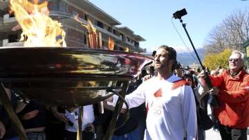 US actor Gerard Butler lights an altar as a torchbearer during the Olympic torch relay of the 2020 Tokyo Olympic Games in the southern Greek town of Sparta, Friday, March 13, 2020.