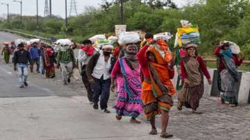  
Migrant labourers along with their families walk on a road after they couldn’t find any transport vehicle to return to their native places, during the complete lockdown to contain the coronavirus spread on Thursday, 26 March