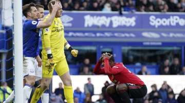 Manchester United's Odion Ighalo, right, reacts after having a shot at goal stopped by Everton's goalkeeper Jordan Pickford, center, during the English Premier League soccer match between Everton and Manchester United at Goodison Park in Liverpool, England, Sunday, March 1