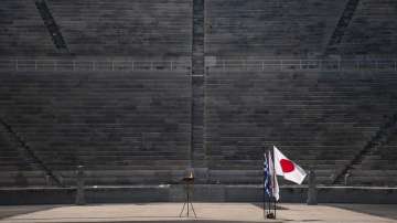 The Japanese flag flies next to an altar with the Olympic Flame of the Tokyo 2020 Olympic Games, inside the Panathenian stadium, in Athens, Sunday, March 15, 2020.