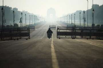 A motorist rides through deserted Rajpath road during a one-day Janata (civil) curfew imposed as a preventive measure against the COVID-19 coronavirus, in New Delhi on March 22, 2020