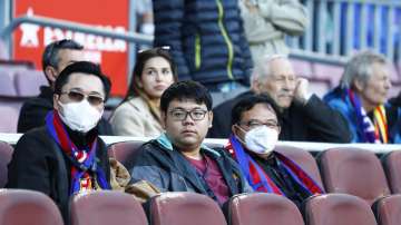 Barcelona fans wear face masks in an attempt to protect there self from the coronavirus, prior a Spanish La Liga soccer match between Barcelona and Real Sociedad at the Camp Nou stadium in Barcelona, Spain, Saturday, March 7