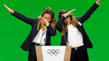 In this Monday, June 24, 2019 filer, Italian snowboarder Michela Moioli, left, and Italian skier Sofia Goggia, right, dab after speaking during the presentation of the Milan-Cortina candidate cities the first day of the 134th Session of the International Olympic Committee (IOC), in Lausanne, Switzerland.?