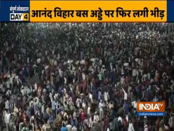 Migrant workers gather at Delhi's Anand Vihar bus stand to board buses back to their states