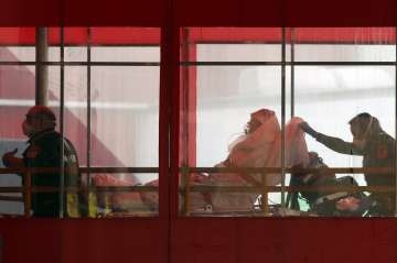 Emergency medical technicians wheel a patient into Elmhurst Hospital Center's emergency room, Tuesda