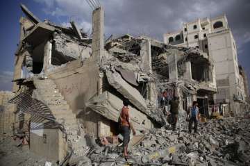 FILE - In this Monday, Jan. 25, 2016 photo, men inspect a house destroyed by a Saudi-led airstrike i