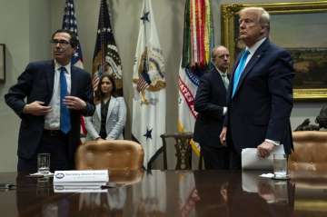 Treasury Secretary Steven Mnuchin and President Donald Trump listen to a question during a conferenc