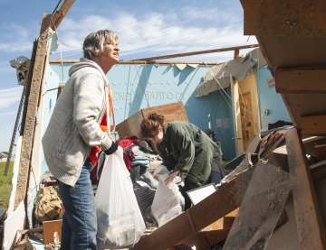 Stephanie Fatheree, right, salvages items from her house damaged from the tornado the previous night