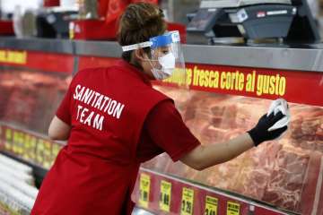 Amid concerns of the spread of COVID-19, Belia Alvarado wipes the meat counter display at El Rancho 