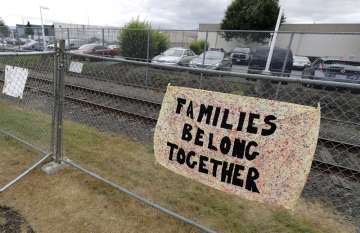 This July 10, 2018 file photo shows a sign that reads "Families Belong Together" on a fence outside 