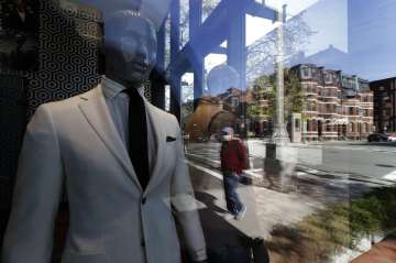 A passer-by wearing a mask out of concern for the COVID-19 coronavirus, background center, walks pas