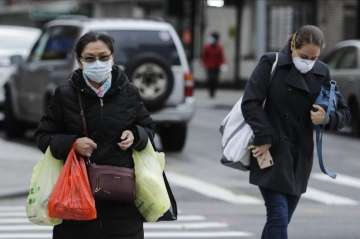 Pedestrians wearing protective masks cross Canal Street Tuesday, April 21, 2020, in New York. (AP Ph