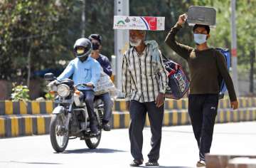 Daily wage laborer from Indian state of Rajasthan Mohammad Yusuf, center, and Azaruddin, walk on foo