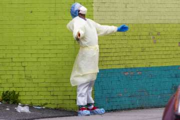 A medic of the Elmhurst Hospital Center medical team reacts after stepping outside of the emergency 