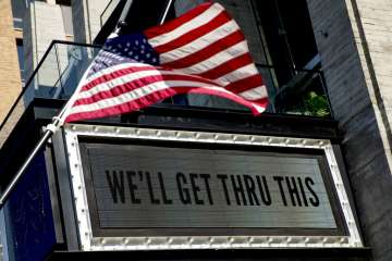 In this April 6, 2020 photo, a sign at The Anthem music venue reads "We'll Get Thru This" at the wharf which is almost completely empty because of the coronavirus outbreak in Washington. The coronavirus pandemic has gut-punched global markets, put 6.6 million Americans out of work and raised the strong likelihood of a recession. But in the Washington lobbying world, business is booming. (AP Photo/Andrew Harnik)