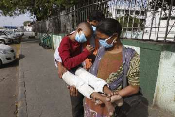 Indian farm laborer Ramakishan, and his wife Devshree pause as they walk carrying their son Gurudev,