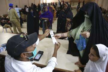 People receive cash vouchers under the government Ehsaas Emergency Cash Programme for families in ne