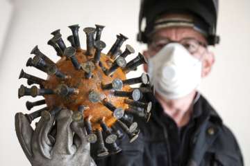 Artist Sebastian Wien shows a coronavirus sculpture at his studio in Dortmund, Germany Wednesday, Ap