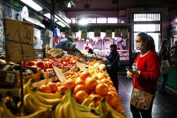 People shop in a covered market in downtown Rome Friday, April 17, 2020. Covered markets were among 