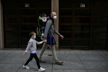 A father with his children wearing face mask to prevent the coronavirus go for a walk at Carlos III 