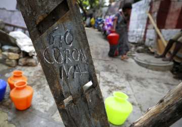 'Go Corona' is written on wooden plank used as a makeshift barricade in a slum during lockdown in Ba