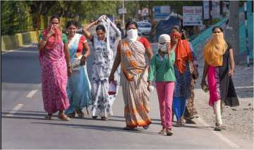  Women walk on a road during the nationwide lockdown imposed in wake of the coronavirus pandemic, in