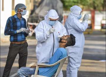 Medics collect a swab sample of a young boy for the test at Sadar, one of the hotspots for COVID-19 during a nationwide lockdown in the wake of coronavirus pandemic, in Lucknow, Monday, April 13, 2020