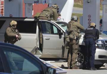 Royal Canadian Mounted Police officers surround a suspect at a gas station in Enfield, Nova Scotia, 