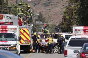 First responders transport an injured person on a stretcher at the scene of a crash involving a Cana