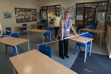 Year 6 teacher Jane Cooper uses a 2 meter length of ruler and pipe to check seat spacings in her cla