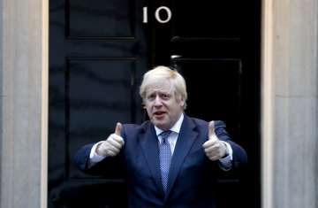 Britain's Prime Minister Boris Johnson shows thumbs up before he applauds on the doorstep of 10 Down