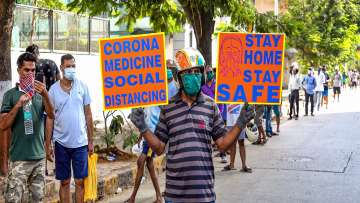  A masked man holds a placard urging citizens to stay at home and maintain social distance outside a wine shop, after authorities permitted the opening of liquor shops with certain restrictions, during the ongoing COVID-19 lockdown, in Mumbai.