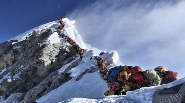 In this photo made on May 22, 2019, a long queue of mountain climbers line a path on Mount Everest