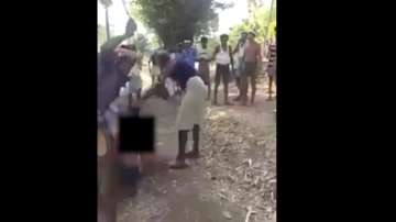 Three men are seen assaulting the 16-year-old teenager in this grab from the viral video, which was recorded in Gujarat's Chota Udepur district