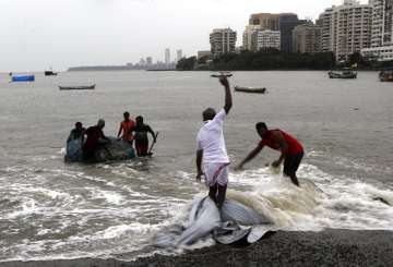 Fishermen pull their nets out of the Arabian Sea in Mumbai, India, Wednesday, June 3, 2020. A storm 