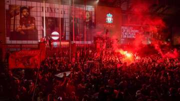 Liverpool soccer fans let off flares outside the Liver Building in Liverpool, England, Friday, June 26, 2020.?