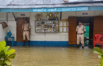 Dibrugarh: CRPF personnel stand guard submerged in floodwaters at CRPF (171) quarter following heavy