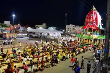 Priests and policemen pull the three chariots of Lord Jagannath, Balarama, and Subhadra from the con