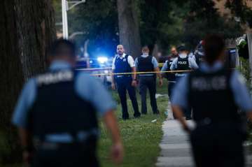 Chicago police officers investigate the scene of a deadly shooting where a 7-year-old girl and a man