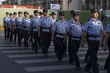 Chinese policemen prepare for duty around a neighborhood sealed off before the official closure of t