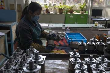 In this April 13, 2020, file photo, a worker assembles gearboxes at the Kofon factory in Huanggang i