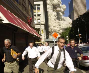 In this Sept. 11, 2001, file photo, people run from the collapse of one of the twin towers at the Wo