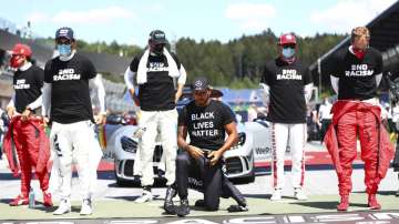 Mercedes driver Lewis Hamilton of Britain, centre, takes a knee in support of the Black Lives Matter movement before the Austrian Formula One Grand Prix race